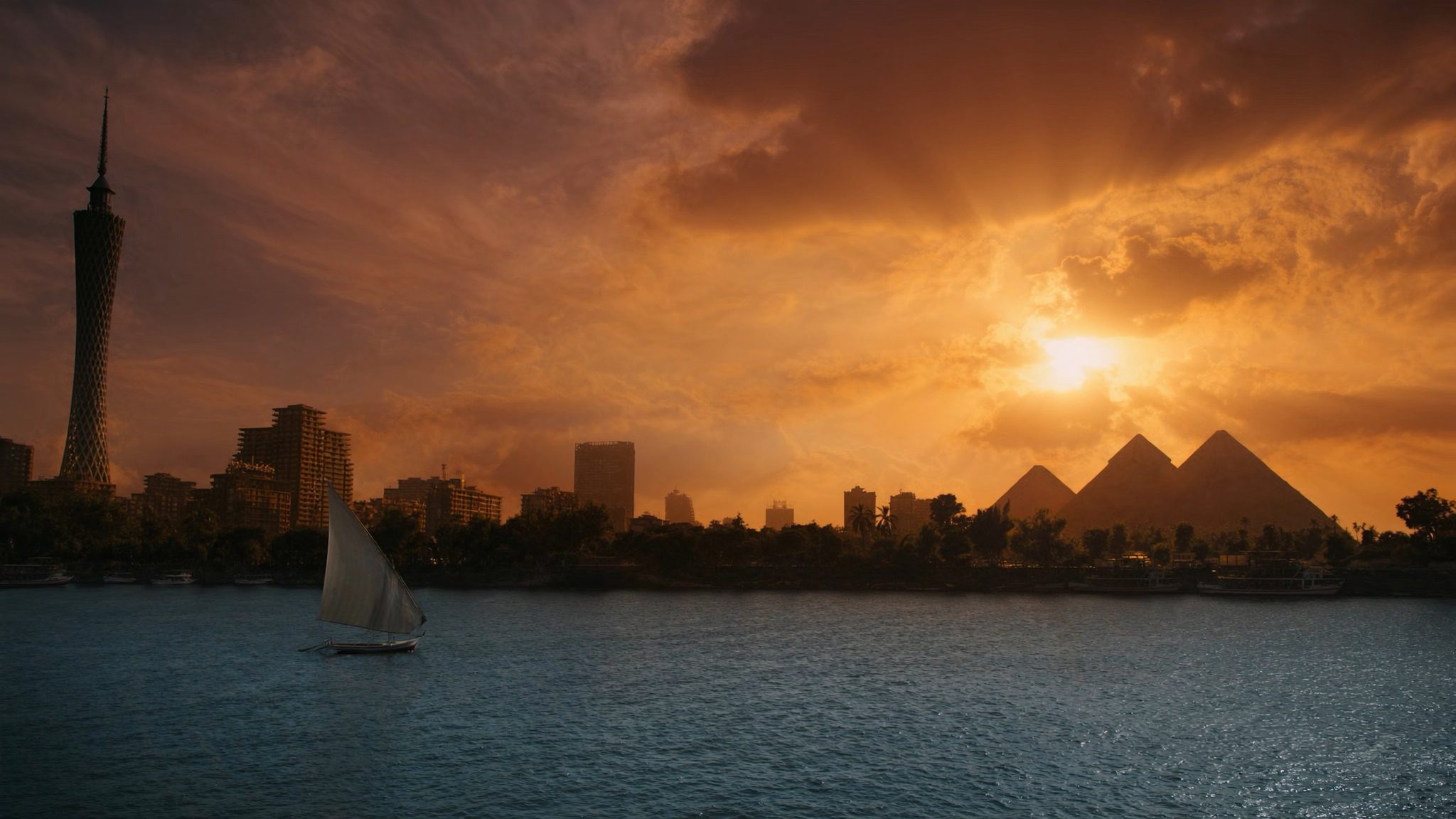 Sunset over the Nile in Cairo: a felucca under sail, the Cairo Tower, and the Giza pyramids